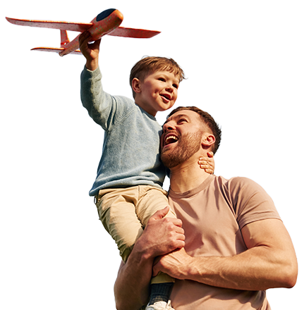 Man holding up small boy with toy plane